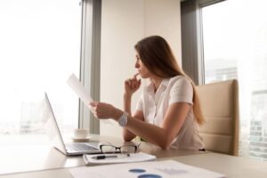 Imagem mulher pensativa lendo documento em um escritório