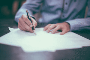 Homem fazendo anotações e calculos para descobrir como usar sua carta contemplada como moeda de troca